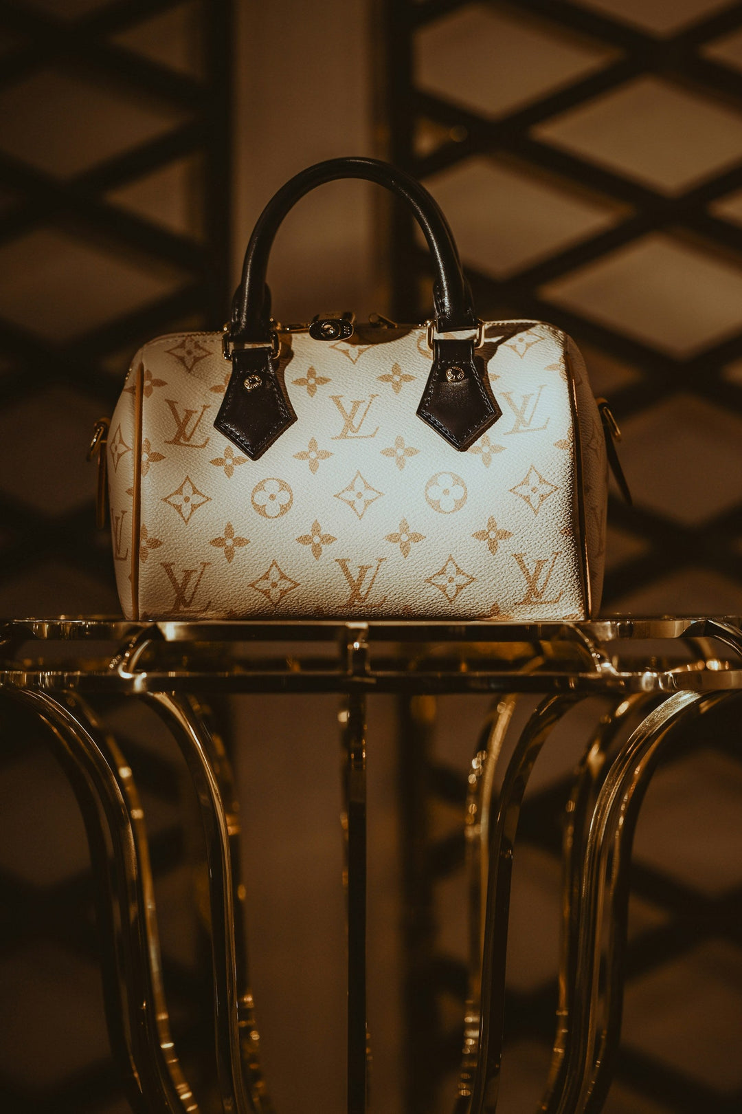Sac Louis Vuitton Speedy en toile Monogram clair posé sur un présentoir doré — sélection Speedy seconde main GABY PARIS